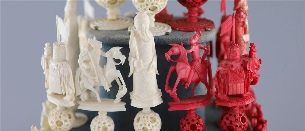A set of 19th century Cantonese carved and red stained ivory chess pieces under dome, white king 20cm high